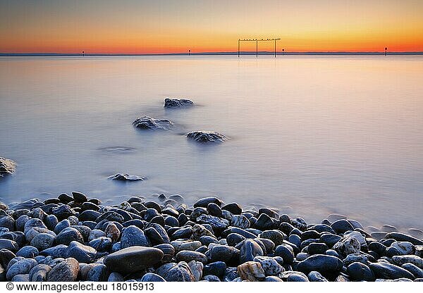 View from Arbon over Lake Constance at sunrise  stones in the foreground and photographed with slow shutter speed  Switzerland  Europe