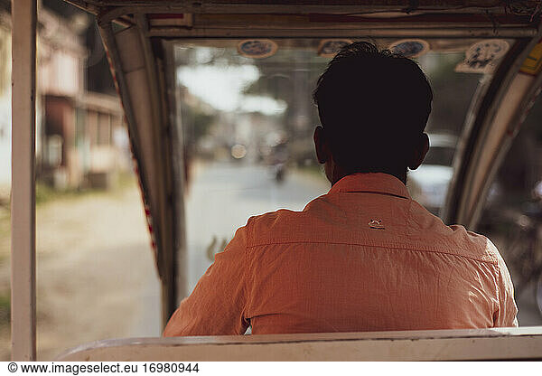 View from behind through autorickshaw taxi drivers window in India