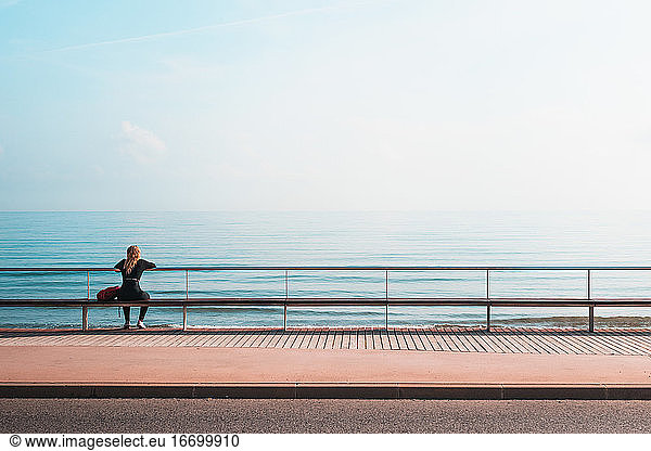 View From Behind To A Blonde Woman Sitting In Front Of The Sea