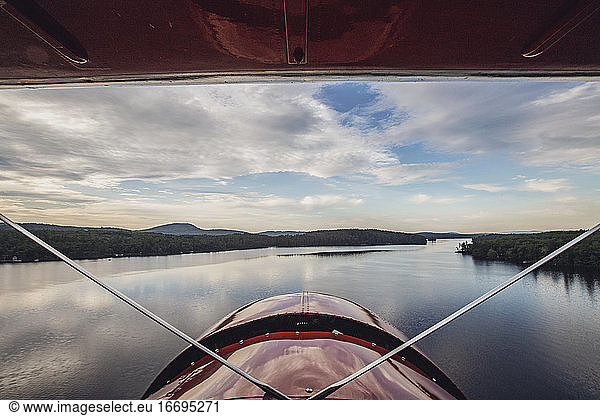 view from cockpit of vintage plane as it flies over Kezar Lake in Main