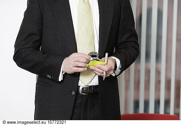 View of a man holding a mobile phone.