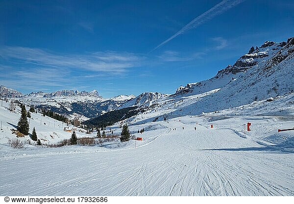 View of a ski resort piste with people skiing in Dolomites in Italy. Canazei  Italy  Europe