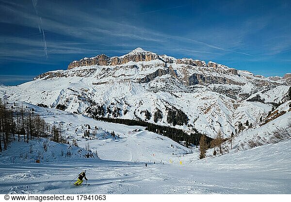 View of a ski resort piste with people skiing in Dolomites in Italy. Ski area Arabba. Arabba  Italy  Europe