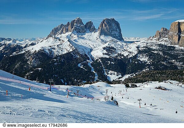 View of a ski resort piste with people skiing in Dolomites in Italy. Ski area Belvedere. Canazei  Italy  Europe