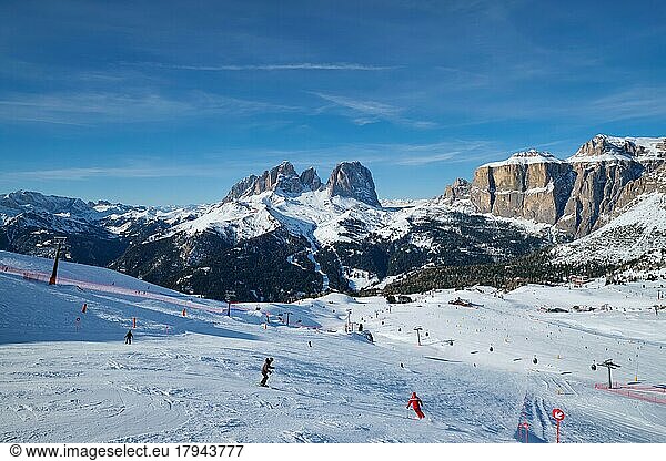 View of a ski resort piste with people skiing in Dolomites in Italy. Ski area Belvedere. Canazei  Italy  Europe