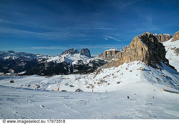 View of a ski resort piste with people skiing in Dolomites in Italy  Ski area Belvedere  Canazei  Italy  Europe