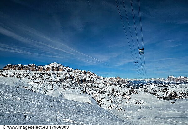 View of a ski resort piste with people skiing in Dolomites in Italy with cable car ski lift  Ski area Arabba  Arabba  Italy  Europe