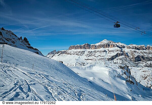 View of a ski resort piste with people skiing in Dolomites in Italy with cable car ski lift. Ski area Arabba. Arabba  Italy  Europe
