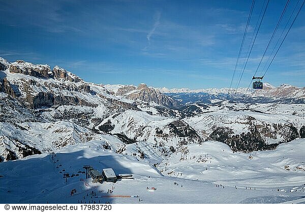 View of a ski resort piste with people skiing in Dolomites in Italy with cable car ski lift  Ski area Arabba  Arabba  Italy  Europe