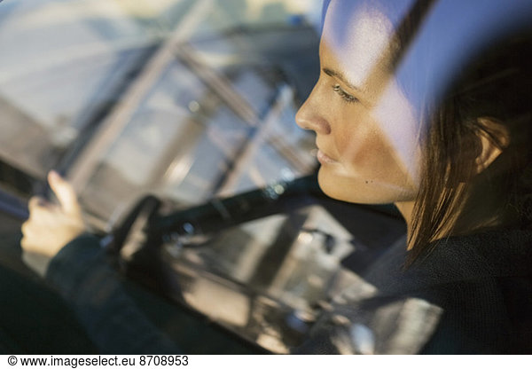 View of businesswoman driving car through window