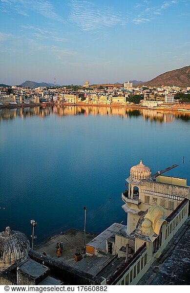 View of famous indian hinduism pilgrimage town sacred holy hindu religious city Pushkar amongst hills with Brahma mandir temple  lake and traditional Pushkar ghats at dusk sunset. Rajasthan  India