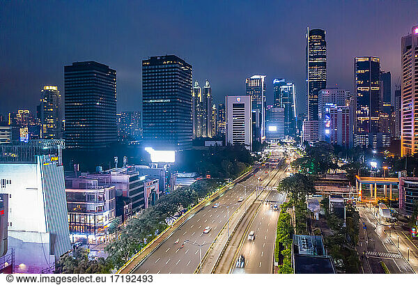 View of fast night time traffic through modern urban city center with skyscrapers in Jakarta  Indonesia Aerial view of multi lane highway through the city