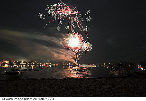 View of fireworks display in sky over sea