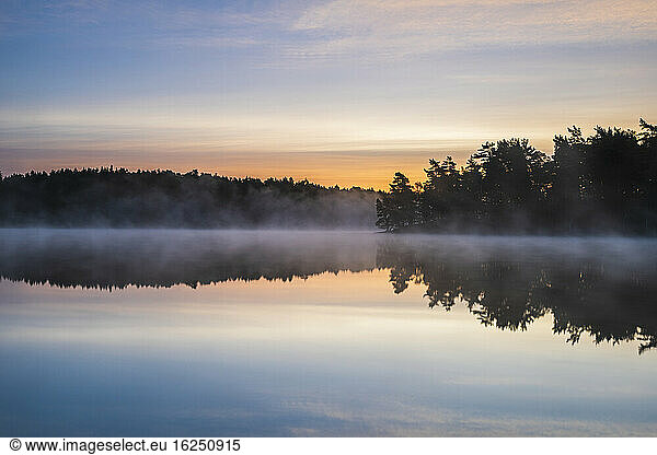 View of foggy lake at sunset