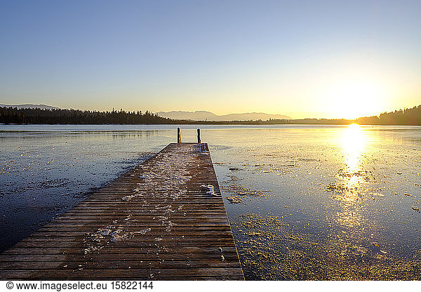 View of frozen Kirchsee with jetty at sunset  Bavaria  Germany
