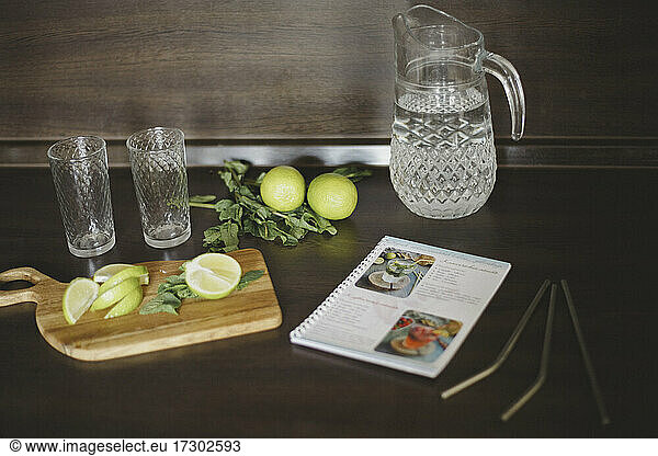 View of glasses  mint  recipe book  limes  reusable straws and jug