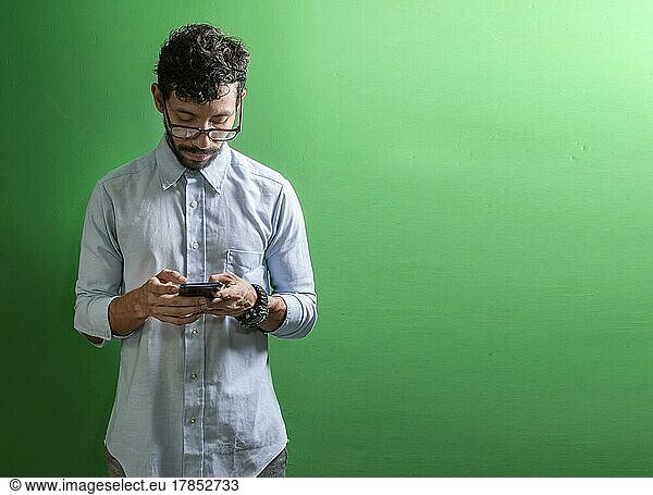 View of handsome man using cell phone isolated  Isolated person in glasses using smart phone  Guy in glasses smiling at cell phone isolated