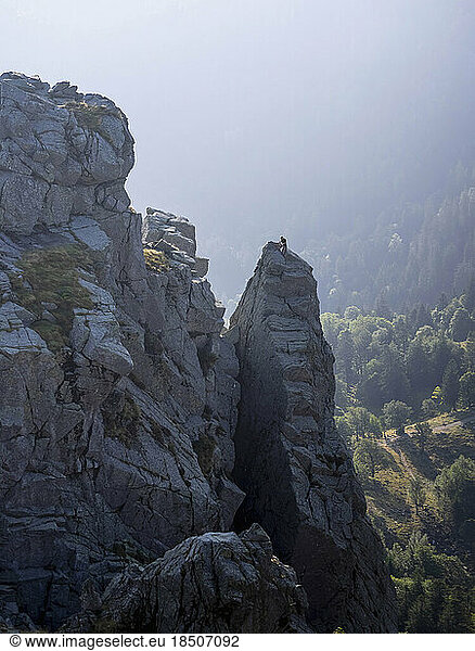 View of hiker seen climbing up over peak of Martinswand mountain  Hohneck  Vosges  France