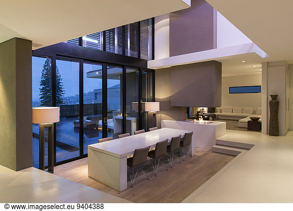 View of modern dining room with large table and chairs at night