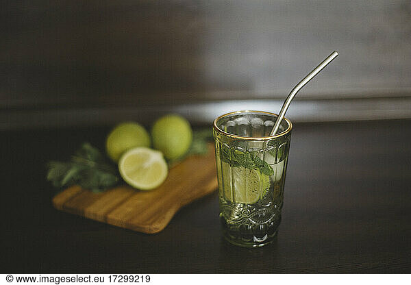 View of non-alcoholic mojito in green glass and reusable straw