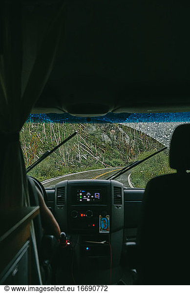 View of open road through windshield of camper van.