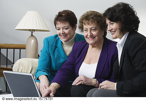 View of smiling business women sitting with a laptop.