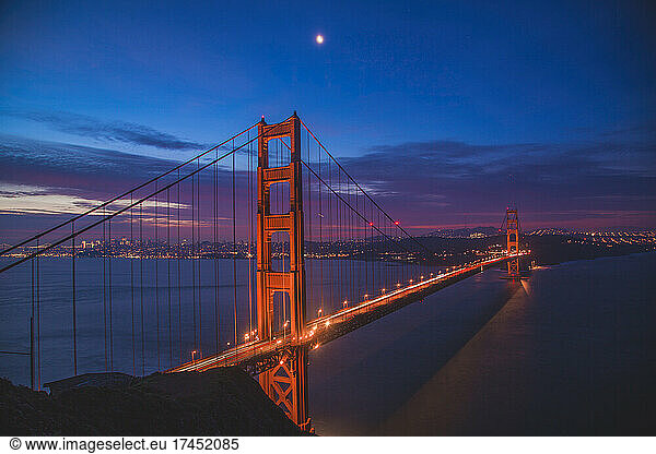 View of the golden gate at dusk with the moon