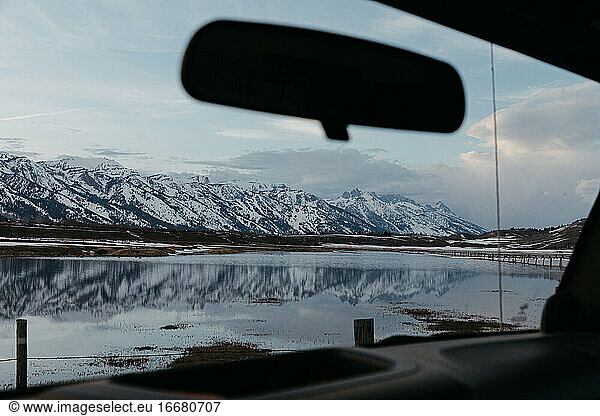 view of the grand teton mountain range and a flooded ranch from car