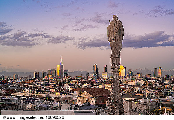View of the statues on the Cathedral of Milan and the skyline of Milan seen on the background