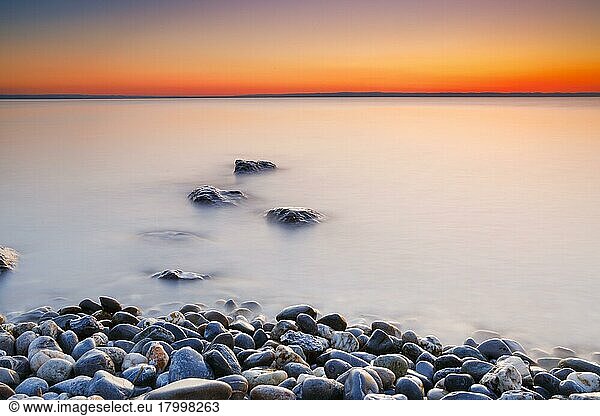 View over Lake Constance at sunrise with stones in the foreground and photographed with slow shutter speed  Canton Thurgau  Switzerland  Europe