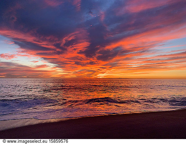 Viewers perspective of beautiful ocean sunset reflected by clouds
