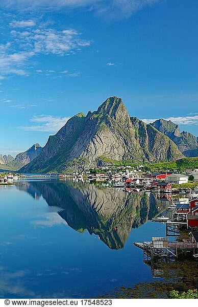 Village view  Reinefjord with mountains and red wooden houses  houses and mountains reflected in the fjord  Reine  Moskenesöy  Lofoten  Nordland  Norway  Europe