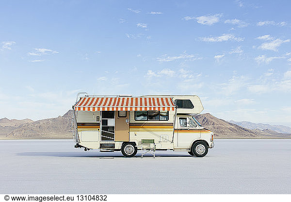 Vintage Dodge Sportsman RV mit gestreifter Überdachung auf Salt Flats geparkt