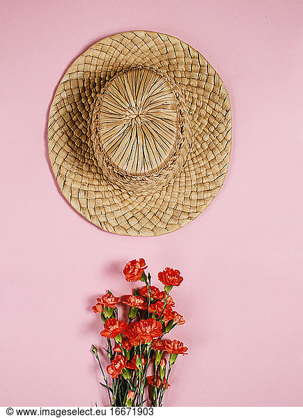 vintage hat on pink background with flower bouquet