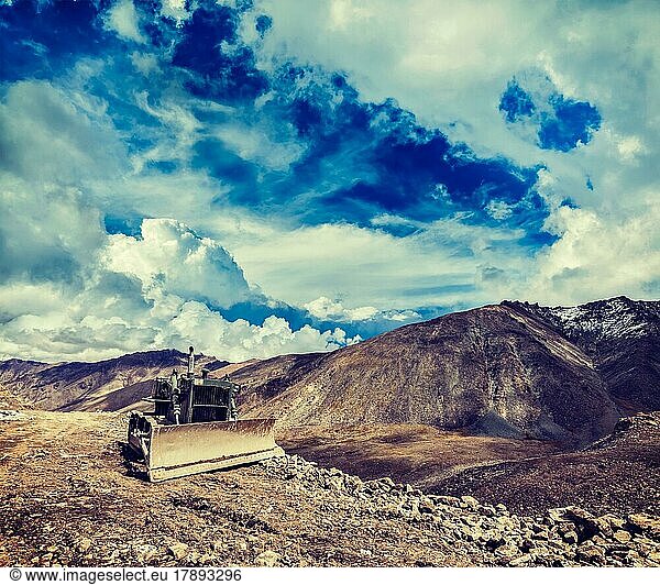 Vintage retro effect filtered hipster style travel image of Bulldozer on road in Himalayas. Ladakh  Jammu and Kashmir  India  Asia