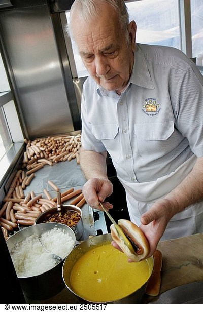 Virginia  Roanoke  Campbell Avenue  Roanoke Weiner Stand  man  cook  prepares  hot dog  mustard  onions  food