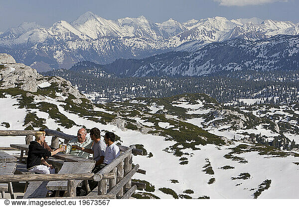 Visitors enjoy a beer on the balcony of a lodge  Salzkammergut  Austria.