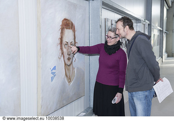 Visitors looking at paintings in an art gallery  Bavaria  Germany