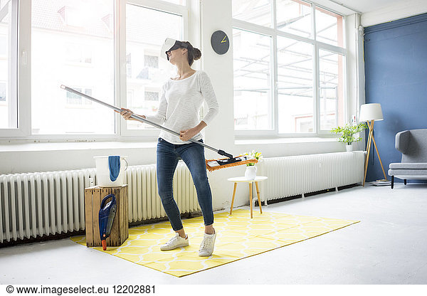 Vital woman at home wearing VR glasses wiping the floor
