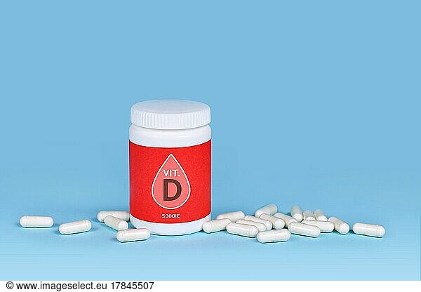 Vitamin D food supplement with container with pills on blue background