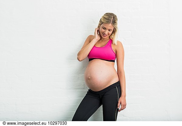 Vollzeitschwangerschaft junge Frau in Sportbekleidung