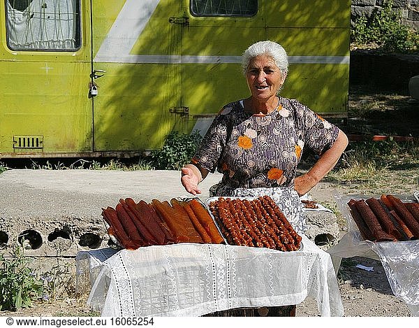Vor dem armenischen Weltkulturerbe  dem Kloster Geghard  verkauft eine alte Frau Fruchtsujukh. Er wird aus geschälten Walnüssen hergestellt  die in Traubensirup getaucht werden  bis sie eine dicke und zarte Schicht bilden. Foto: Andr? Maslennikov