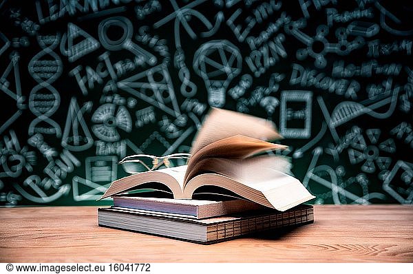 Vor der Tafel Bücher und Gläser auf den Tisch stellen