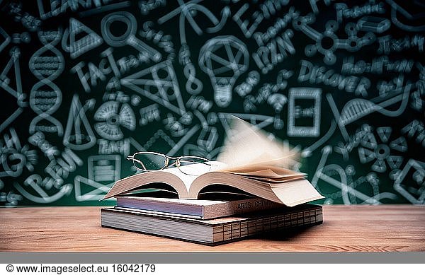 Vor der Tafel Bücher und Gläser auf den Tisch stellen