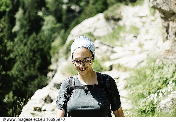 Vorderansicht einer lächelnden Wanderin auf einem Bergpfad