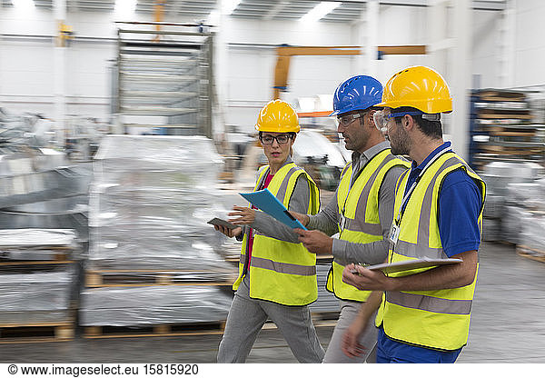 Vorgesetzter und Arbeiter gehen und sprechen im Lager