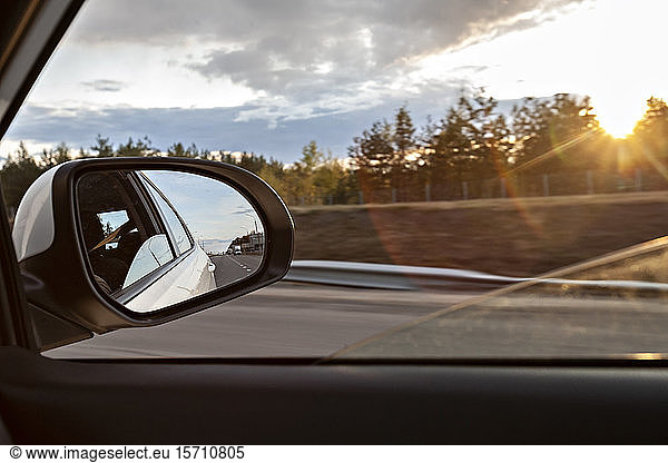 Voronezh  Voronezh Oblast  Russia  Shiny side-view mirror with sun setting in background