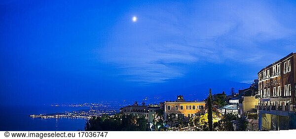 Vulkan Ätna und der Mond bei Nacht  Panoramablick von der Piazza IX Aprile auf Corso Umberto  der Hauptstraße in Taormina  Sizilien  Italien  Europa  gesehen. Dies ist ein Panoramafoto des Vulkans Ätna und des Mondes in der Nacht  gesehen von der Piazza IX Aprile auf dem Corso Umberto  der Hauptstraße in Taormina  Sizilien  Italien  Europa