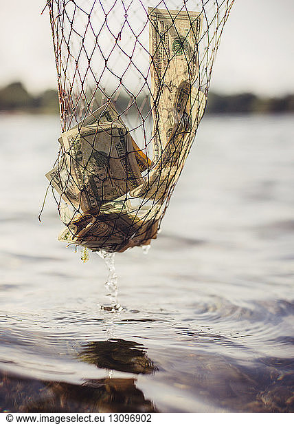 Währung im Fischernetz  das über den See tropft