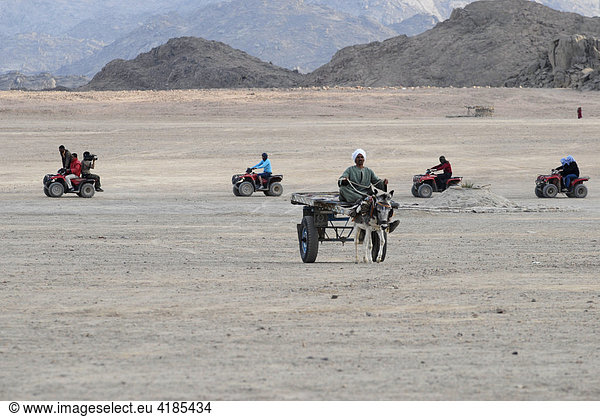 Wüste Hurghada am Roten Meer in Ägypten. Eselkarren tifft auf Gruppe von Quad Fahrern  Hurhgada  Ägypten.